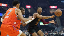 Cleveland Cavaliers' Isaac Okoro, right, passes against Oklahoma City Thunder's Darius Bazley, left, and Shai Gilgeous-Alexander in the first half of an NBA basketball game, Saturday, Jan. 22, 2022, in Cleveland. (AP Photo/Tony Dejak)