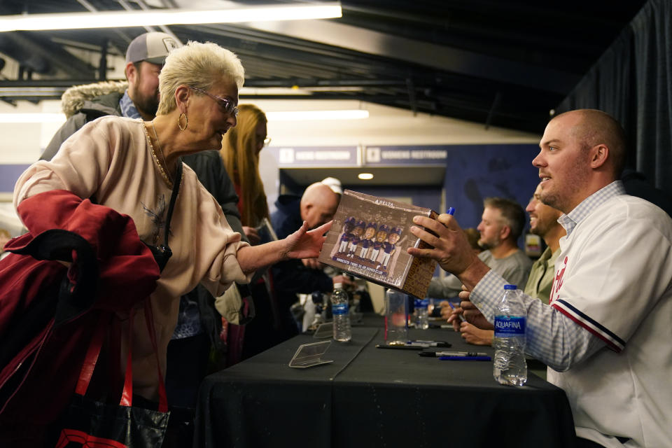 Minnesota Twins relief pitcher Caleb Thielbar signs a bobble head collection for a fan during the team's annual fan fest at Target Field Saturday, Jan. 28, 2023, in Minneapolis. (AP Photo/Abbie Parr)