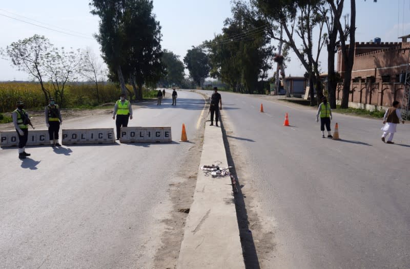 Police officers stand guard at a blocked road leading to Manga village after an outbreak of coronavirus disease (COVID-19), in Marden