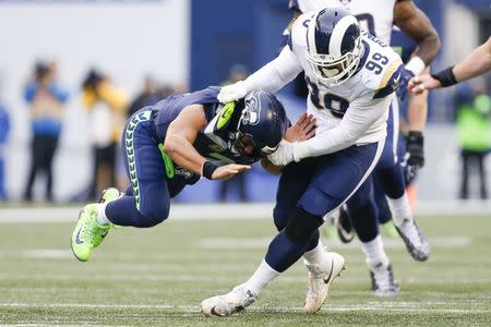 Dec 17, 2017; Seattle, WA, USA; Los Angeles Rams defensive end Aaron Donald (99) brings down Seattle Seahawks quarterback Russell Wilson (3) after forcing a backwards pass during the second quarter at CenturyLink Field. Mandatory Credit: Joe Nicholson-USA TODAY Sports