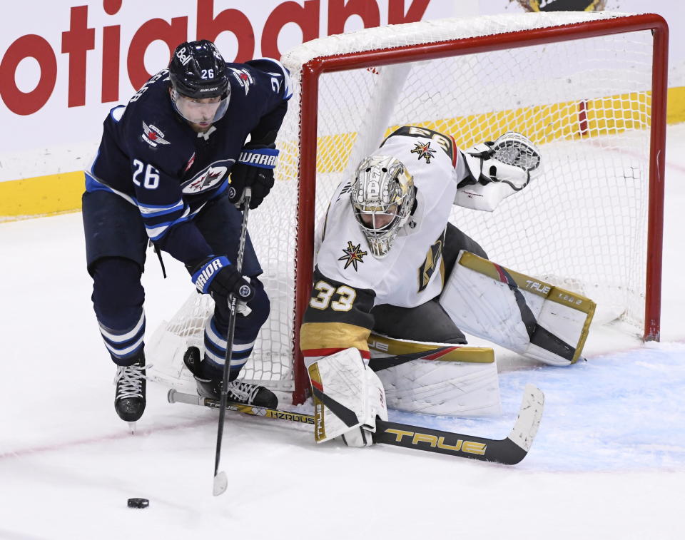 Winnipeg Jets' Blake Wheeler (26) looks to pass the puck in front of Vegas Golden Knights goaltender Adin Hill (33) during the third period of an NHL hockey game in Winnipeg, Manitoba on Tuesday, Dec. 13, 2022. (Fred Greenslade/The Canadian Press via AP)