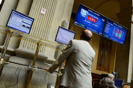 A trader looks an index billboard at Madrid's stock exchange. A full-blown bailout for Spain, the fourth-largest economy in the eurozone, would dwarf the rescues of Ireland, Greece and Portugal and strain the resources of the EU bloc to the limit