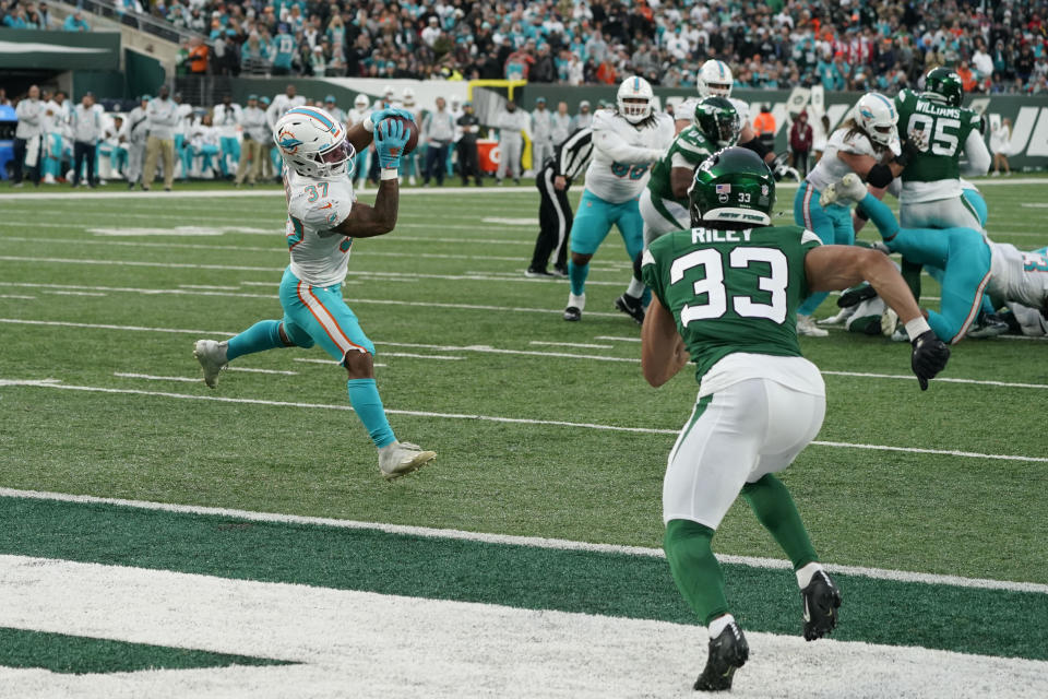 Miami Dolphins' Myles Gaskin, left, makes a catch just before scoring a touchdown during the second half of an NFL football game against the New York Jets, Sunday, Nov. 21, 2021, in East Rutherford, N.J. (AP Photo/Corey Sipkin)