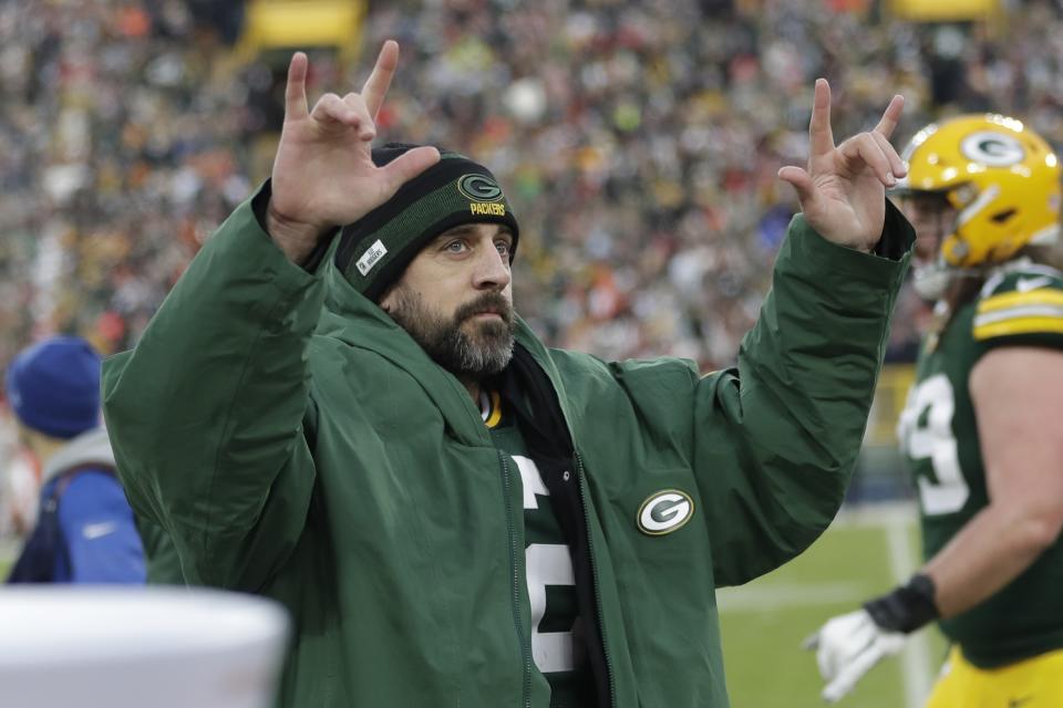 Green Bay Packers' Aaron Rodgers celebrates after throwing career touchdown pass 443 during the first half of an NFL football game against the Cleveland Browns Saturday, Dec. 25, 2021, in Green Bay, Wis. The pass breaks the previous Green Bay Packers record held by Brett Favre. (AP Photo/Aaron Gash)