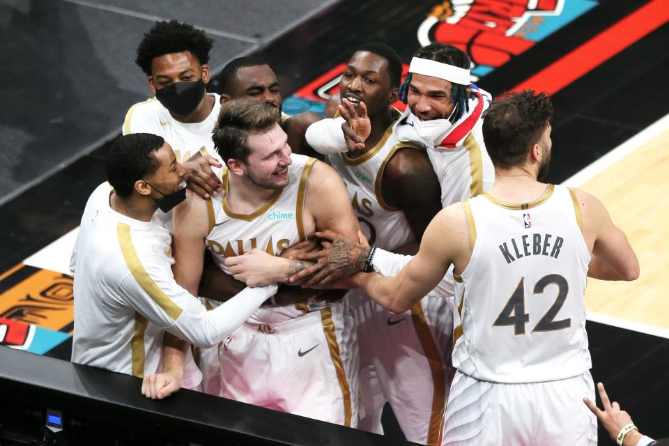 Dallas Mavericks guard Luka Doncic celebrates with teammates after hitting a buzzer-beating 3-pointer to beat the Memphis Grizzlies.