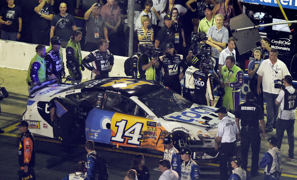 A NASCAR official tries to get between drivers Ryan Newman, in green suit near the car's hood, and Clint Bowyer after the NASCAR All-Star Race at Charlotte Motor Speedway in Concord, N.C., Saturday, May 18, 2019. (AP Photo/Mike McCarn)