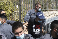 Israeli police officers detain a protester during a demonstration against a proposed measure to curtail public demonstrations during the current nationwide lockdown due to the coronavirus pandemic, in front of the Knesset, Israel's parliament in Jerusalem, Tuesday, Sept. 29, 2020. (AP Photo/Sebastian Scheiner)