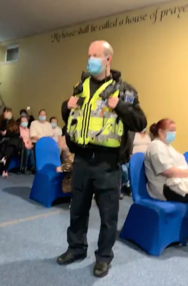 A police officer stands among the congregation at the church in Cardiff, Wales. (Wales News Service)