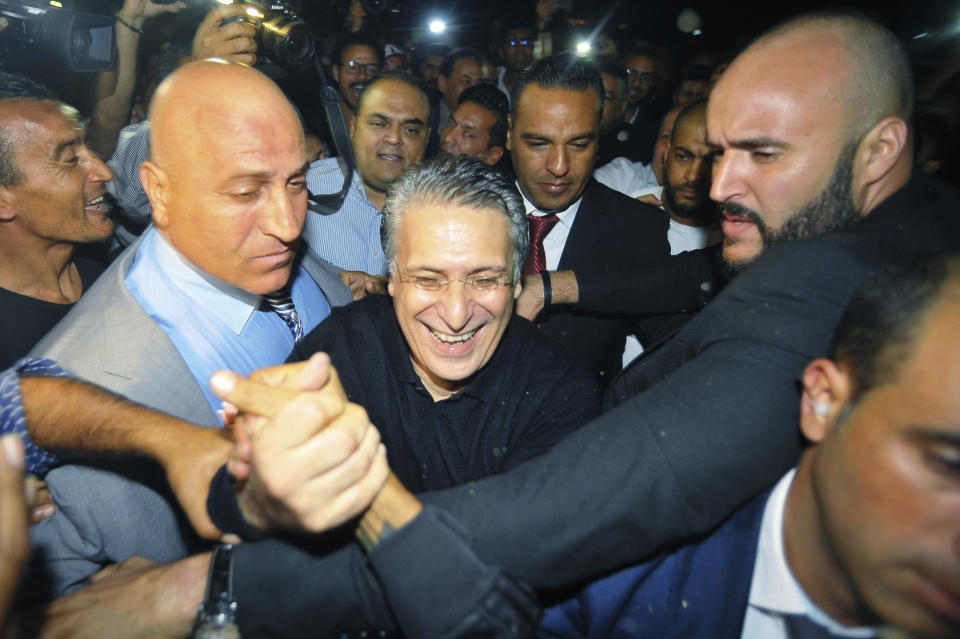 Tunisian presidential candidate and media mogul Nabil Karoui, center, is greeted by jubilant crowds after he was released from prison in Mannouba, Tunisia, Wednesday Oct. 9, 2019, just four days before the upcoming presidential runoff election. Karoui has been jailed since August under investigation for alleged money laundering and tax fraud that he asserts as a politically motivated smear campaign. (AP Photo)