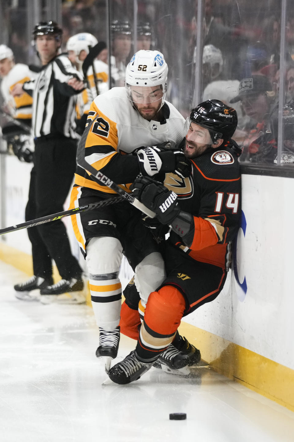 Anaheim Ducks' Adam Henrique (14) is checked by Pittsburgh Penguins' Mark Friedman (52) during the first period of an NHL hockey game Friday, Feb. 10, 2023, in Anaheim, Calif. (AP Photo/Jae C. Hong)