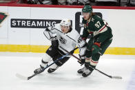 Los Angeles Kings' Blake Lizotte (46) and Minnesota Wild's Kirill Kaprizov (97) pursue the puck in the first period of an NHL hockey game, Tuesday, Jan. 26, 2021, in St. Paul, Minn. (AP Photo/Jim Mone)