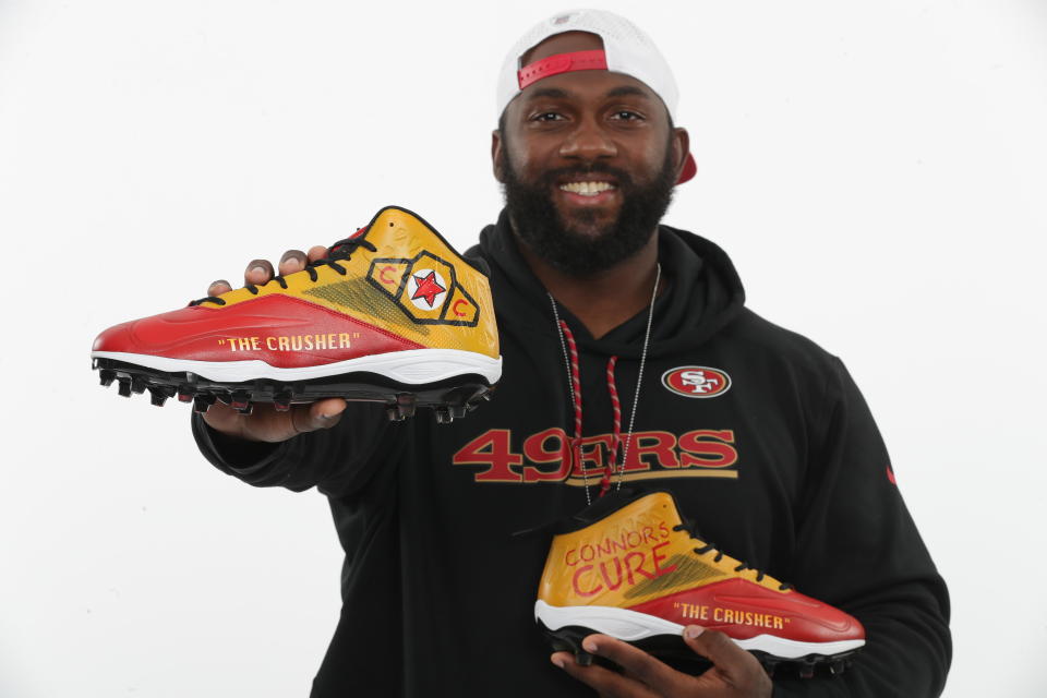 San Francisco 49ers Defensive Tackle Earl Mitchell holds his custom made "Connor's Cure" cleats — San Francisco 49ers