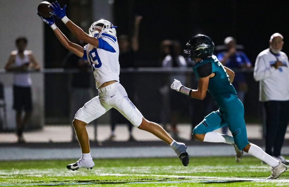 Barron Collier Cougars receiver Jesse Mikolinski (19) stretches to make a catch and score a touchdown during the second quarter of the Catfish Bowl against the Gulf Coast Sharks at Gulf Coast High School in Naples on Friday, Nov. 3, 2023.