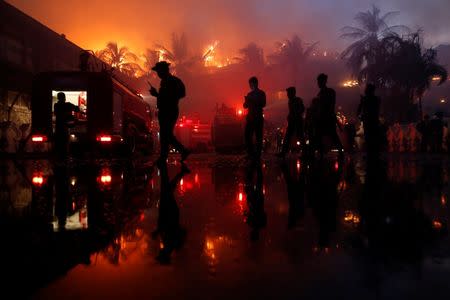 Police officers stand guard during a fire at Kandawgyi Palace hotel in Yangon, Myanmar October 19, 2017 . REUTERS/Soe Zeya Tun