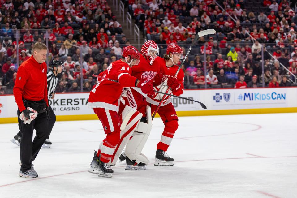 Red Wings goaltender Ville Husso is helped from the ice by defenseman Shayne Gostisbehere (41) and defenseman Moritz Seider during the first period of the Wings' 4-3 loss to the Ducks on Monday, Dec. 18, 2023, at Little Caesars Arena.