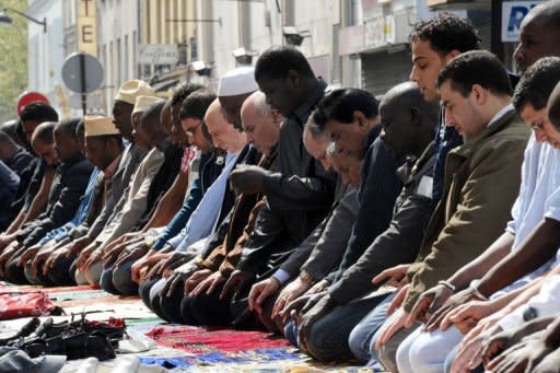 Muslims kneel in the street as part of Friday's prayers at the rue des Poissonniers in Paris. Clearly aimed at fathers, husbands or religious leaders who force women to wear face-veils, and applicable to offences committed in public or in private, the new ban on veils imposes a fine of 30,000 euros and a year in jail