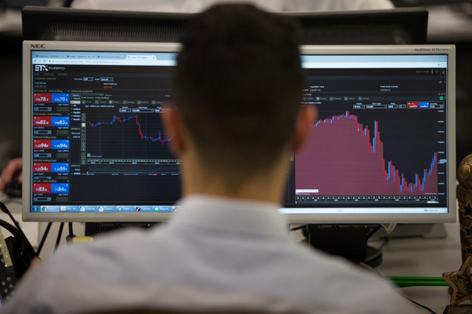 A trader studies information on trading screens at ETX Capital in central London. Photo: Daniel Leal-Olivas/AFP via Getty Images