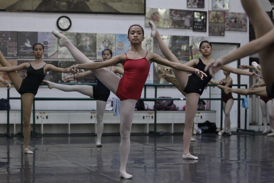 In this photo taken Nov. 25, 2012, Filipino slum dweller Jessa Balote, center, practices with other students during a class at Ballet Manila in the Philippine capital. Balote, who used to tag along with her family as they collect garbage at a nearby dumpsite, is a scholar at Ballet Manila's dance program. As an apprentice, she makes around 7,000 pesos ($170) a month, sometimes double that, from stipend and performance fees. (AP Photo/Aaron Favila)