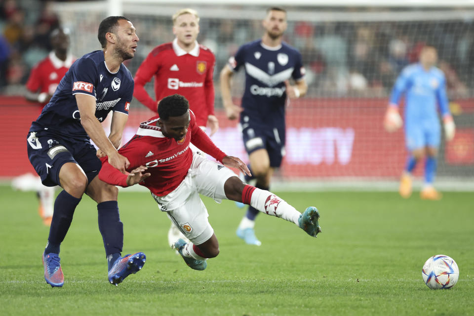 Manchester United's Ethan Laird and Melbourne Victory's Roderick Miranda, left, battle for the ball during the soccer match between Manchester United and Melbourne Victory at the Melbourne Cricket Ground, Australia, Friday, July 15, 2022. (AP Photo/Asanka Brendon Ratnayake)