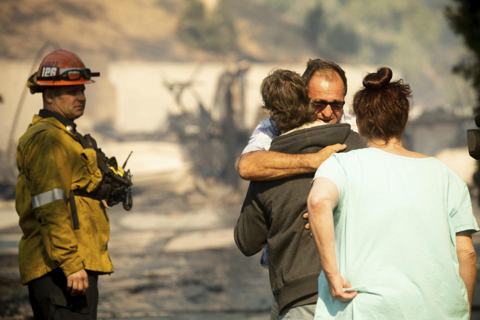 Eyed Jarjour comforts a neighbor who lost his Jolette Ave. home to the Saddleridge Fire on Friday, Oct. 11, 2019, in Granada Hills, Calif. (AP Photo/Noah Berger)