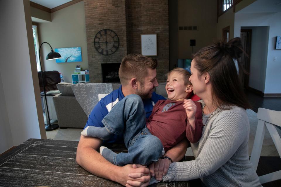 Andrew Smith, 35, plays with his son Jonathan Smith, 5, with his wife Sarah Smith, 33, at right in their new home in Rochester Hills on Oct. 4, 2019.