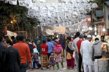 People walk below posters of an election candidate ahead of the 11th general election in Dhaka, Bangladesh, December 28, 2018. REUTERS/Mohammad Ponir Hossain