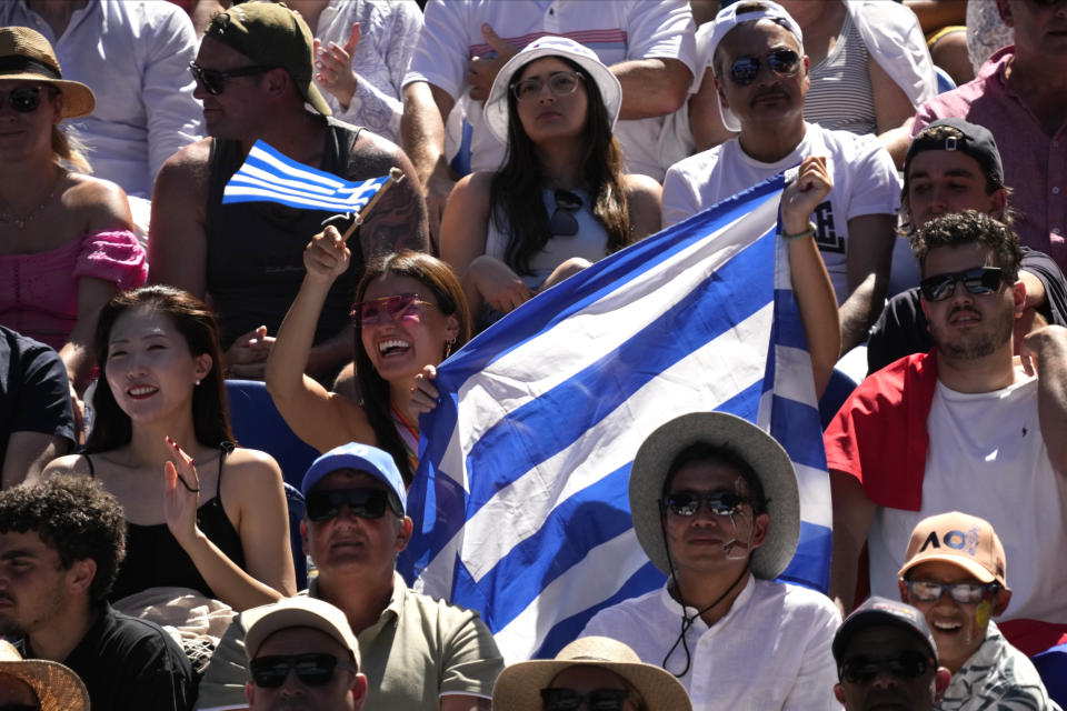 Supporters of Stefanos Tsitsipas of Greece hold his national flag during his semifinal against Karen Khachanov of Russia at the Australian Open tennis championship in Melbourne, Australia, Friday, Jan. 27, 2023. (AP Photo/Dita Alangkara)