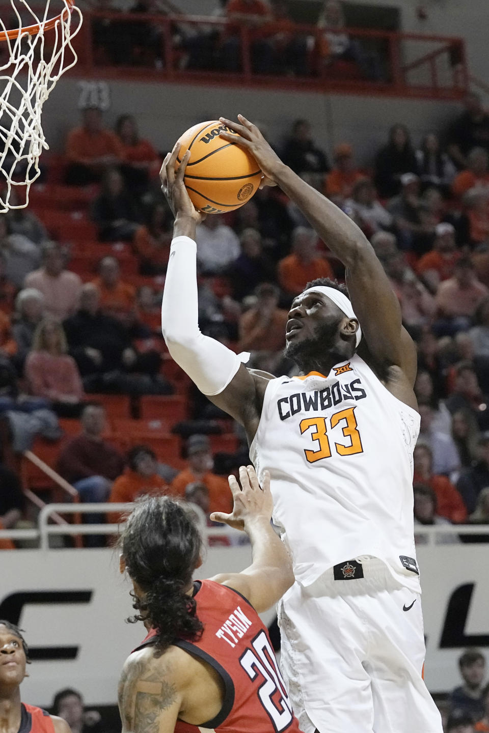 Oklahoma State forward Moussa Cisse (33) shoots over Texas Tech guard Jaylon Tyson (20) in the first half of an NCAA college basketball game Wednesday, Feb. 8, 2023, in Stillwater, Okla. (AP Photo/Sue Ogrocki)