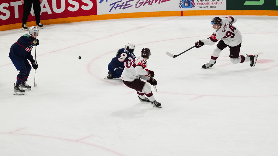 Latvia's Kristians Rubins (94) shoots the game winning shot in overtime of their bronze medal match against the United States at the Ice Hockey World Championship in Tampere, Finland, Sunday, May 28, 2023. Latvia won 4-3. (AP Photo/Pavel Golovkin)