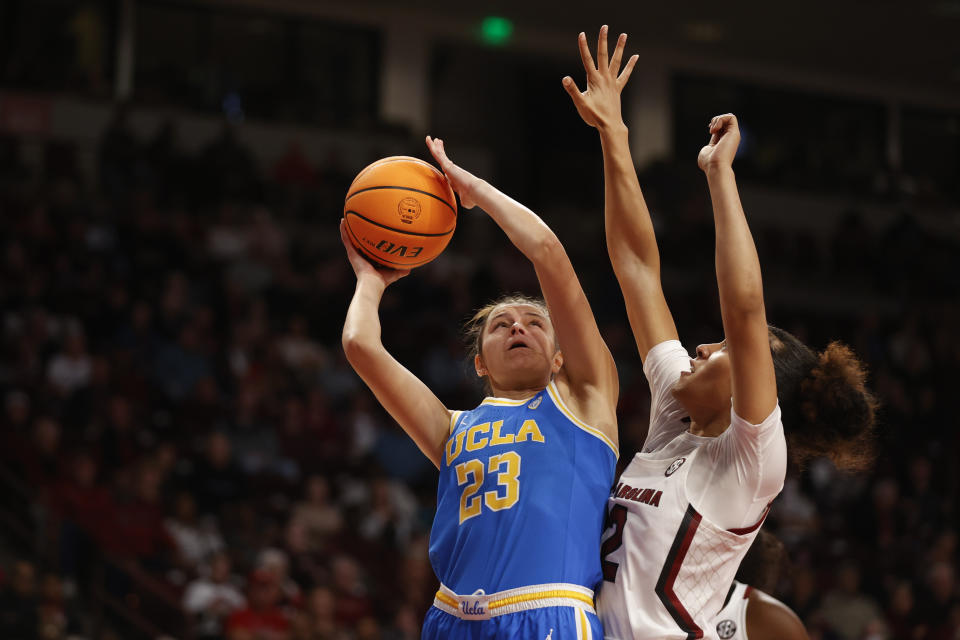 FILE - UCLA forward Gabriela Jaquez (23) shoots against South Carolina guard Brea Beal during the first half of an NCAA college basketball game in Columbia, S.C., Tuesday, Nov. 29, 2022. Women's college basketball has typically kept players around compared to the frequent early exits to the professional ranks that are so common on the men's side. But the women's game has gotten even older with players having extra eligibility from the COVID-19 pandemic. That has first-year players facing more fifth- and sixth-year players, creating a bigger gap to overcome in experience and strength than before. (AP Photo/Nell Redmond, File)