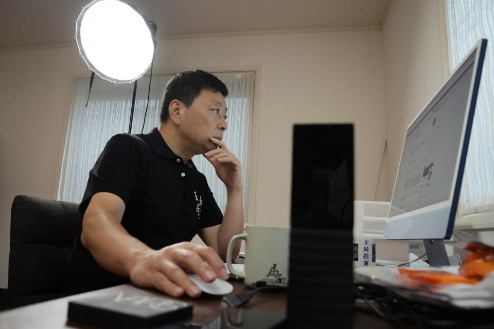 Wang Zhi'an checks his website during an interview with the Associated Press in Tokyo on Oct. 5, 2022. Chinese investigative journalist Wang once exposed corruption, land seizures, and medical malpractice for state broadcaster CCTV. Today, he's in exile in Japan, and starting again as an independent journalist on YouTube. (AP Photo/Eugene Hoshiko)