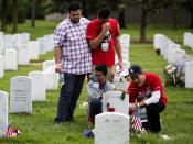 <p>The family of Army Staff Sgt. Daniel A. Quintana gather at his grave on Memorial Day in Section 60 at Arlington National Cemetery in Arlington, Va., Monday, May 30, 2016. From left are Quintana’s brothers, Jonathan Echeveria and Tony Belmontez, his son Daniel Quintana III, and his fathe, Daniel Quintana Sr.. Army Staff Sgt. Daniel A. Quintana died Sept. 10, 2011, while serving during Operation Enduring Freedom. (Photo: Carolyn Kaster/AP) </p>