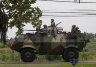 Malaysian soldiers with in an armored personnel carrier drive towards the area where the stand-off with Sulu gunmen is on going, in Tanduo village on March 4, 2013. Malaysia's government vows to beef up its security forces in an eastern state where nearly 30 people have been reported killed as police and soldiers grapple with a bizarre invasion by followers of a former Philippine sultanate. AFP PHOTO / MOHD RASFAN