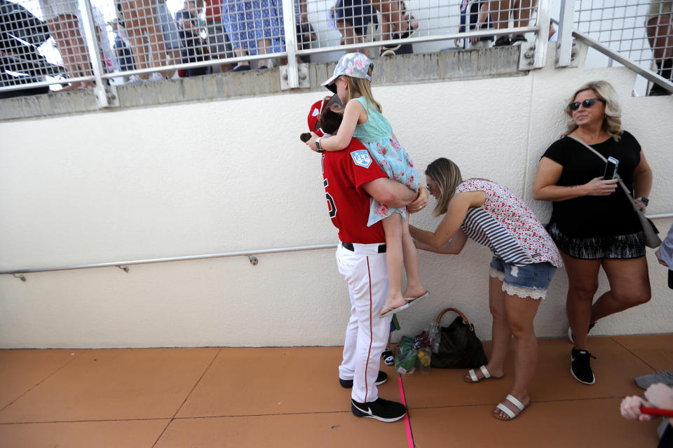 Boston Red Sox pitcher Steven Wright (35) holds his daughter Ella, 6, before a spring training baseball game against the New York Yankees in Fort Myers, Fla., Saturday, Feb. 23, 2019. (AP Photo/Gerald Herbert)