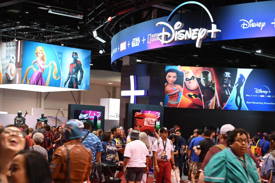 Attendees visit the Disney+ streaming service booth at the D23 Expo, billed as the "largest Disney fan event in the world," on August 23, 2019 at the Anaheim Convention Center in Anaheim, California. - Disney Plus will launch on November 12 and will compete with out streaming services such as Netflix, Amazon, HBO Now and soon Apple TV Plus. (Photo by Robyn Beck / AFP)        (Photo credit should read ROBYN BECK/AFP/Getty Images)