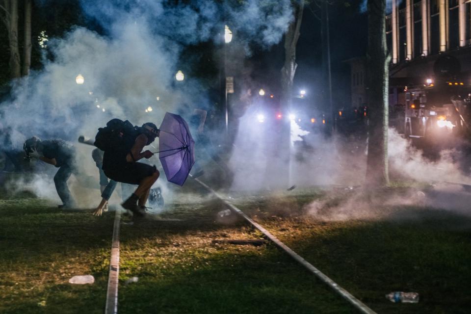 Demonstrators retreat from tear gas in front of the Kenosha County Courthouse.