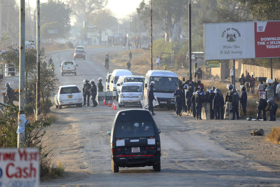 Police stop and search vehicles at a check point ahead of a planned protest in Harare, Friday, Aug. 16, 2019.. Zimbabwe's police patrolled the streets of the capital Friday morning while many residents stayed home fearing violence from an anti-government demonstration planned by the opposition. (AP Photo/Tsvangirayi Mukwazhi)