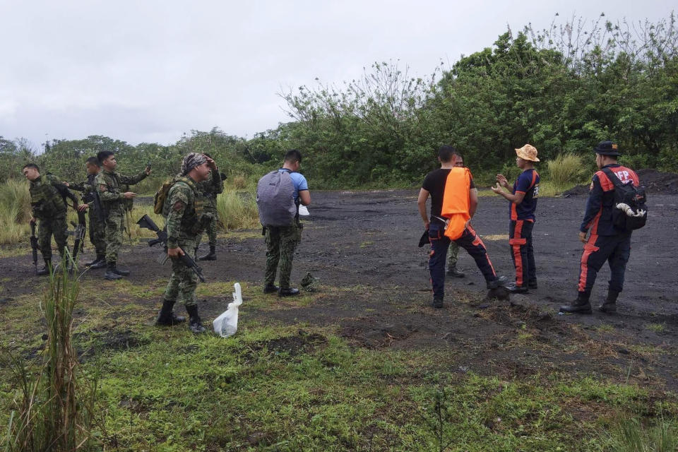 In this handout photo provided by the Bureau of Fire Protection Camalig, rescuers prepare to search for passengers of a Cessna 340 aircraft with registry number RP-C2080 at Tumpa Gulley, Camalig town, Albay province, the Philippines on Monday Feb. 20, 2023. Philippine authorities said Monday they would verify whether the wreckage of a small plane spotted near the crater of a restive Mayon volcano was that of a Cessna aircraft that went missing with four people on board over the weekend. (Bureau of Fire Protection Camalig via AP)