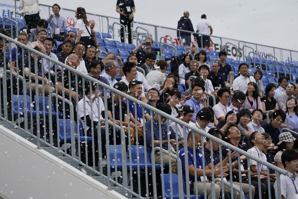 TOKYO, JAPAN - SEPTEMBER 13: Officials react to sprayed artificial snow from snow-making machines to ease heat during a canoe sprint test event for the Tokyo 2020 Olympic and Paralympic Games at Sea Forest Waterway, on September 13, 2019 in Tokyo, Japan. (Photo by Toru Hanai/Getty Images)