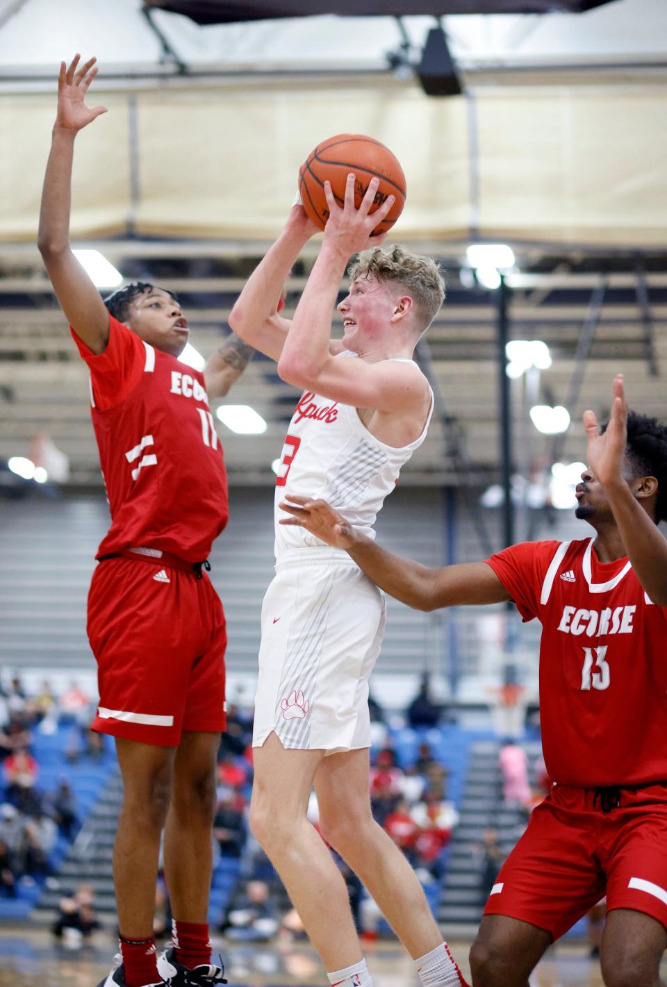 Laingsburg's Eli Woodruff, center, shoots betwen Ecorse's Deonatae Jude, left, and Tahjay Rose, Tuesday, March 21, 2023, at Ypsilanti Lincoln High School.