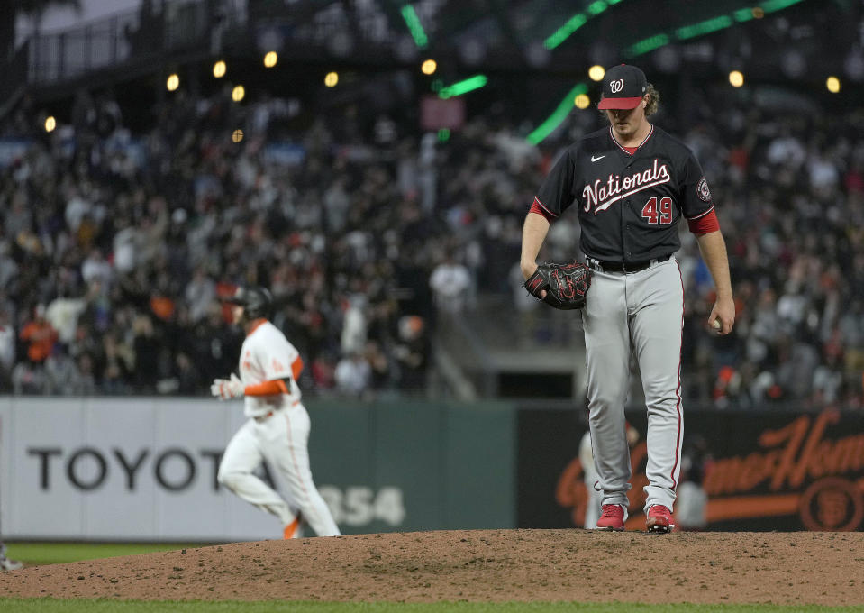 San Francisco Giants' Darin Ruf, background left, rounds the bases after hitting a solo home against Washington Nationals relief pitcher Sam Clay (49) during the fifth inning of a baseball game Friday, July 9, 2021, in San Francisco. (AP Photo/Tony Avelar)