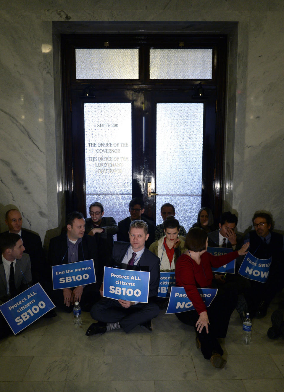 Protesters calling for a statewide anti-discrimination law that includes sexual and gender orientation protections block the front entrance to the governor's office during a stand-in at the Capitol in Salt Lake City on Monday, Feb. 9, 2014. Organizer and Equality Utah volunteer Donna Weinholtz told The Salt Lake Tribune that demonstrators are asking Herbert to issue an executive order passing the anti-discrimination measure. (AP Photo/The Salt Lake Tribune, Francisco Kjolseth)