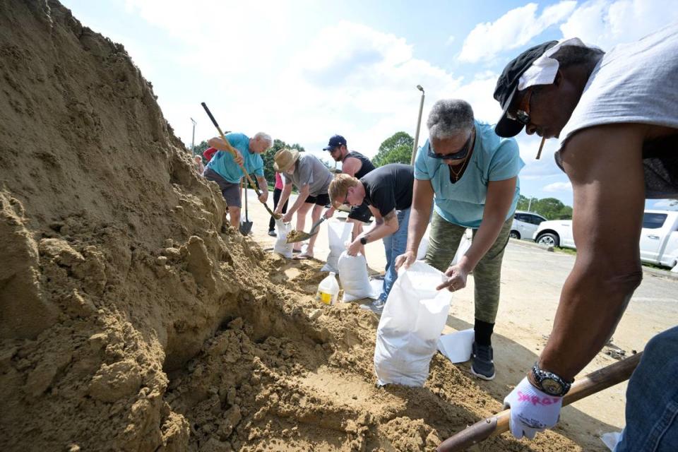 Johnny Ford, right, and his wife Jerria Ford fill free sand bags at an Orange County park in preparation for the arrival of Hurricane Ian, Monday, Sept. 26, 2022, in Orlando, Fla.