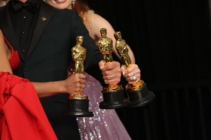Oscars winners holding their statues