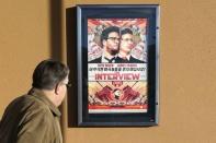 A man walks by the poster for the film "The Interview" outside the Alamo Drafthouse theater in Littleton, Colorado December 23, 2014. REUTERS/Rick Wilking