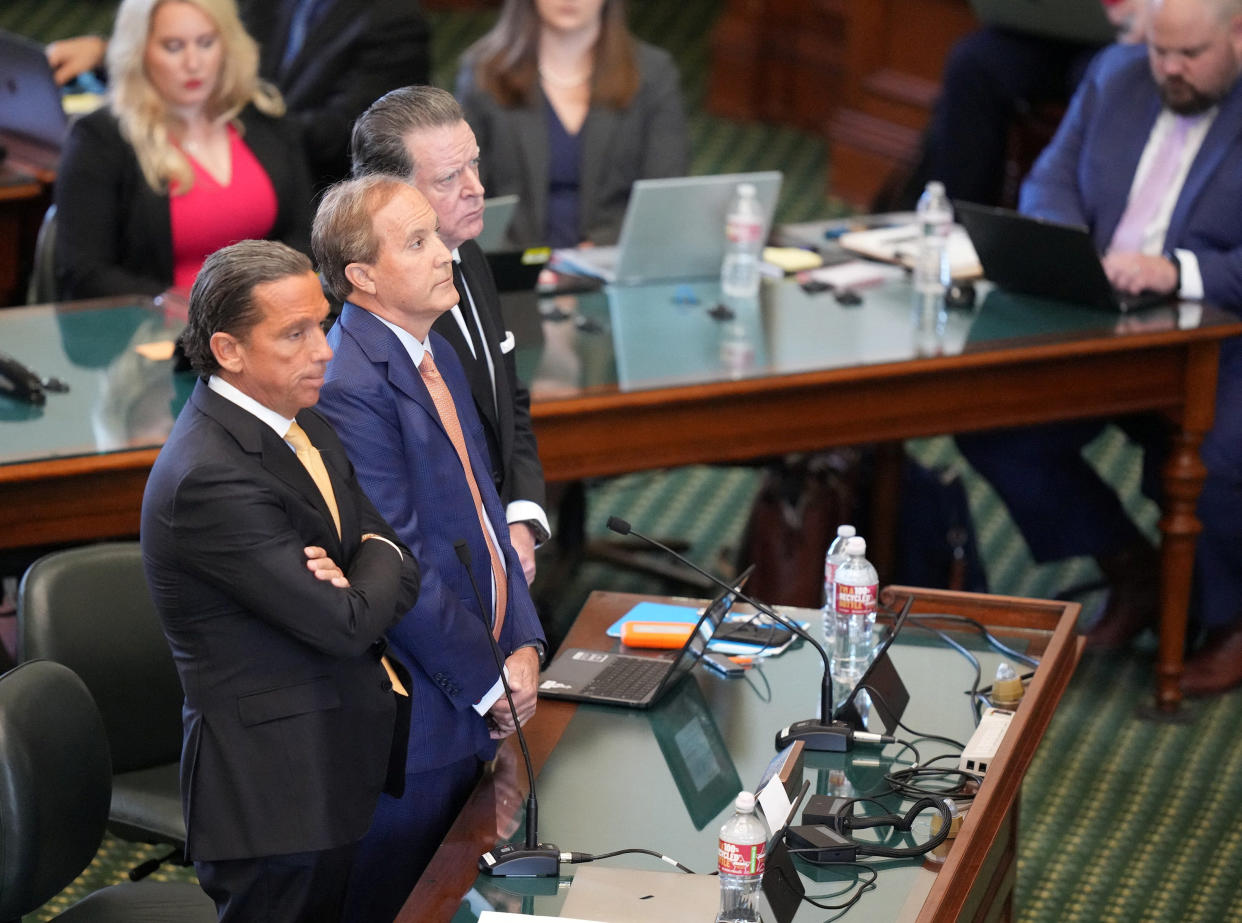 Attorney General Ken Paxton stands with his attorneys Tony Buzbee and Dan Cogdell as he pleads not guilty in his impeachment trial at the Texas Capitol in Austin.