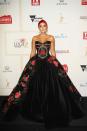 <p>The stunning actress divided opinion with this black gown scattered with red roses, which she accompanied with a red head scarf.</p>