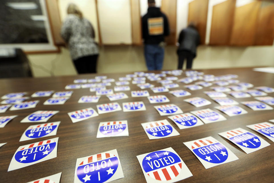 FILE - In this Nov. 6, 2018 file photo, people vote at Jamestown Town Hall in Kieler, Wis. Conservatives are asking a judge to find the Wisconsin Elections Commission in contempt for not immediately purging more than 200,000 voters from the rolls. A judge last month ordered the purge of voters who may have moved and didn&#39;t respond within 30 days to notification sent by the elections commission in October 2019. (Nicki Kohl/Telegraph Herald via AP, File)