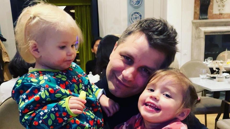 Pasha Kovalev holding his two daughters Maven and Noa