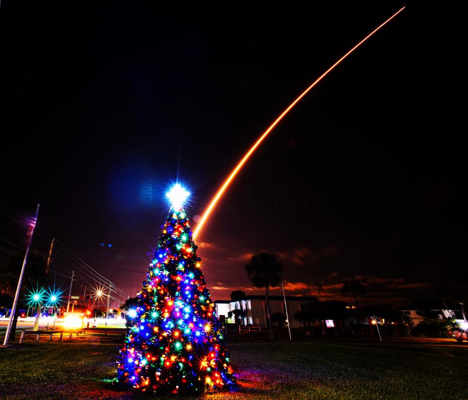 In a Yuletide scene at Sidney Fischer Park in Cocoa Beach, a SpaceX Falcon 9 rocket ascends from Cape Canaveral Space Force Station after its 12:07 a.m. Thursday liftoff.